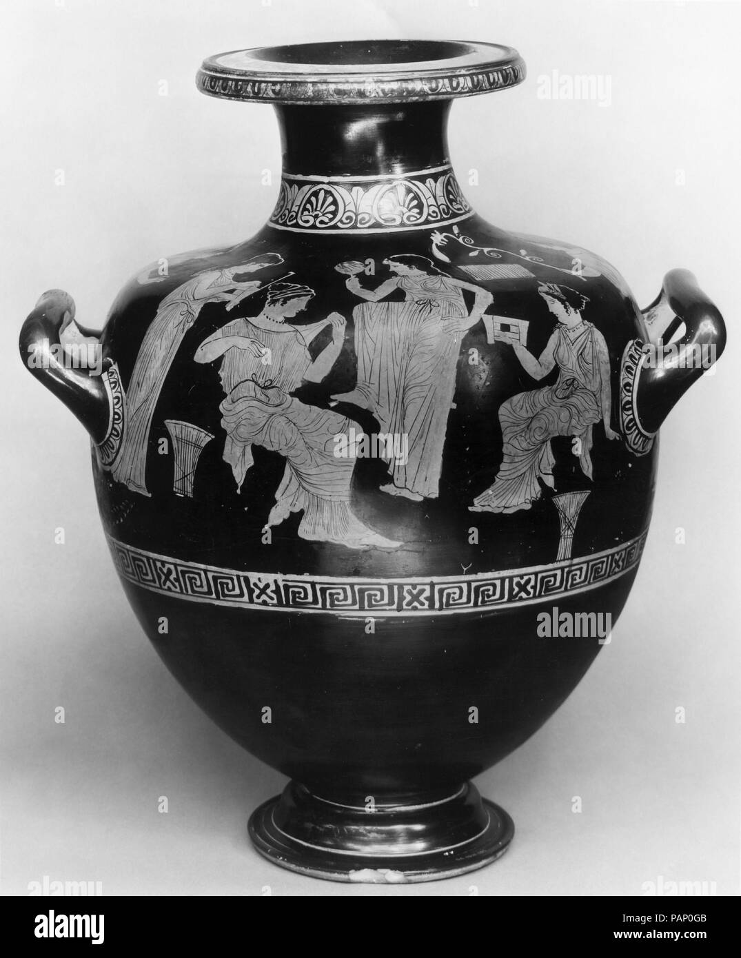 Terracotta hydria: kalpis (water jar). Culture: Greek, Attic. Dimensions: H.: 17 x 12 3/16 in. (43.2 x 31 cm). Date: ca. 420-410 B.C..  Women outdoors  The setting is indicated by the uneven terrain and the wisps of plant life growing around the figures. Otherwise, the iconography would be that of women in a domestic interior. The ladies are finely dressed and embellished with jewelry. They are shown with their caskets, wool baskets, and a mirror. Museum: Metropolitan Museum of Art, New York, USA. Stock Photo