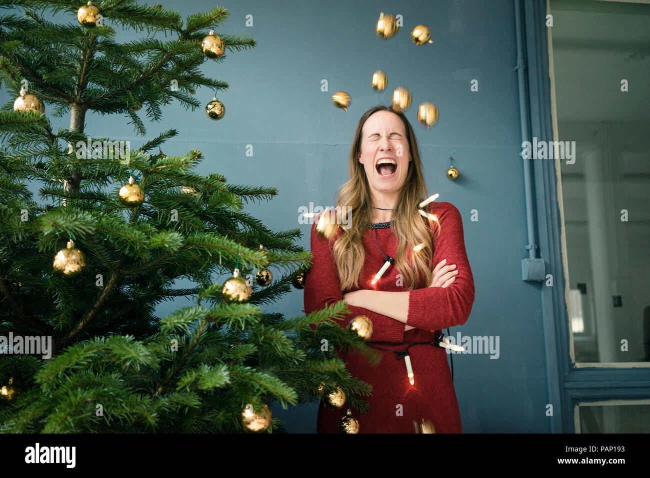 Screaming woman standing besides Christmas tree Stock Photo