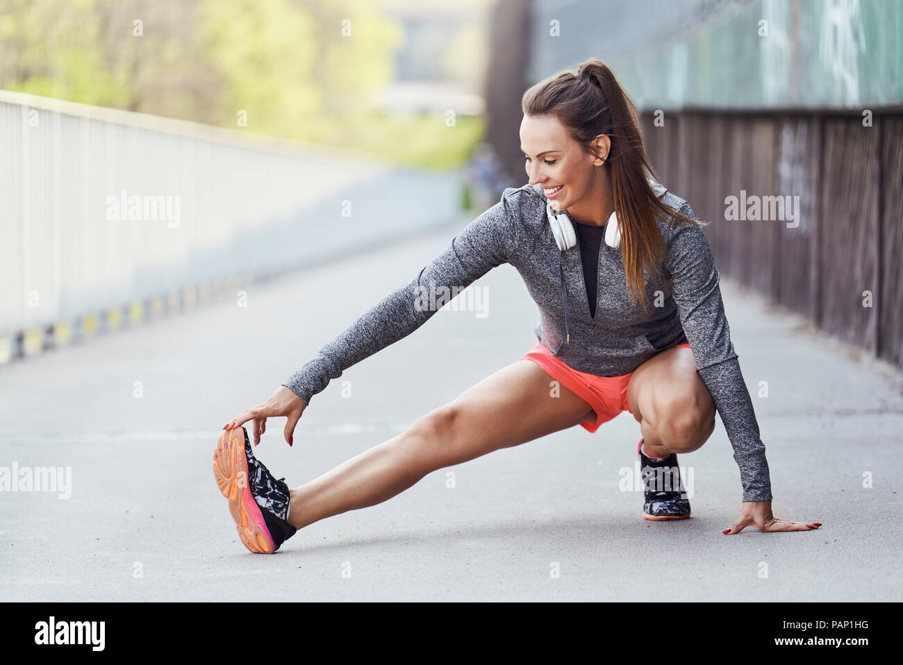 Female runner stretching legs during urban workout Stock Photo - Alamy