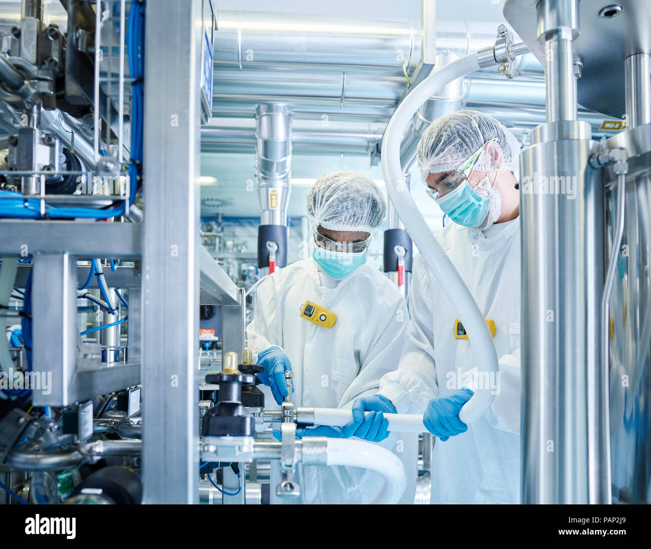 Chemical laboratory technicians fitting hose Stock Photo