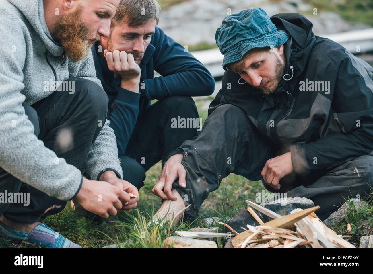 Norway, Lofoten, Moskenesoy, Young men starting a camp fire Stock Photo