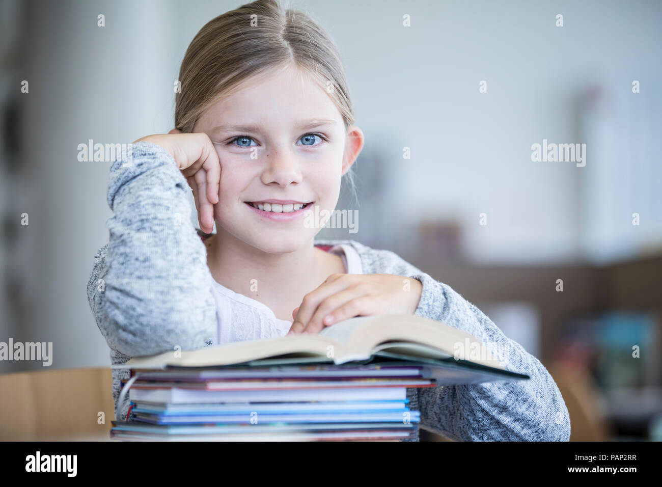 Portrait of smiling schoolgirl with books in school Stock Photo - Alamy