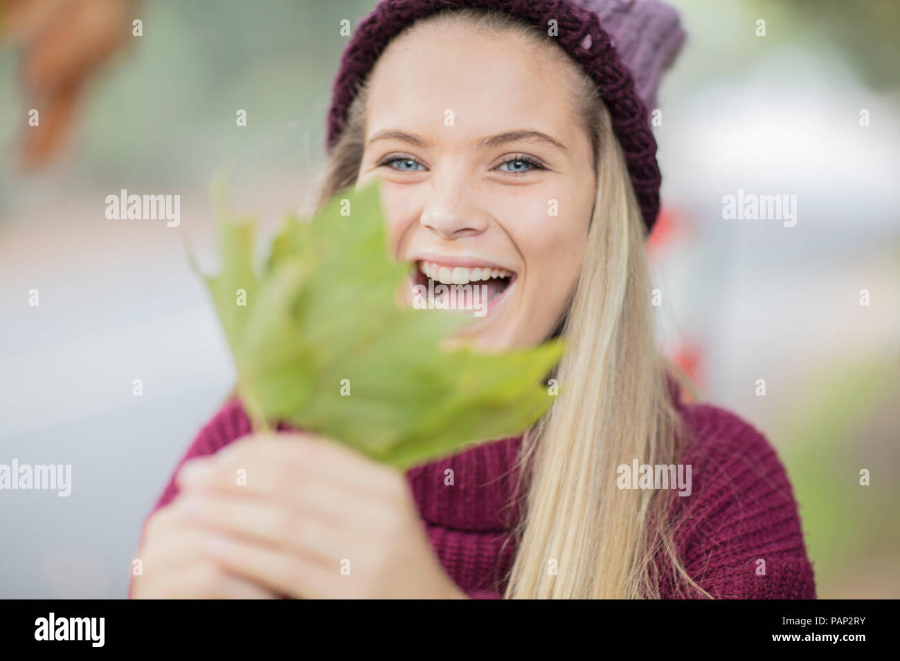 Portrait of happy teenage girl holding leaf Stock Photo
