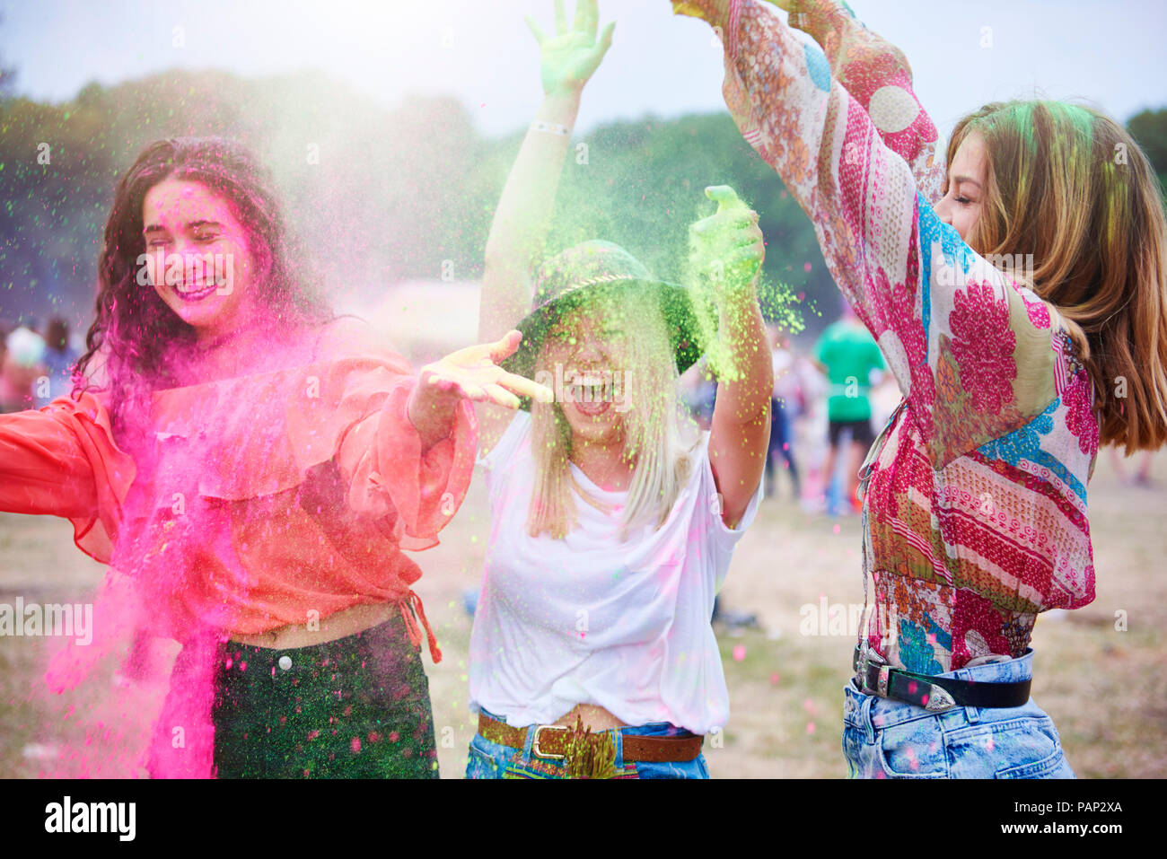 Portrait of friends at music festival, colour powder Stock Photo