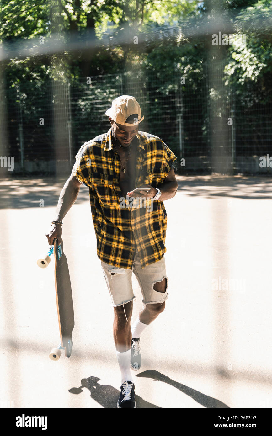 Cool young man in skate park, using smartphone Stock Photo