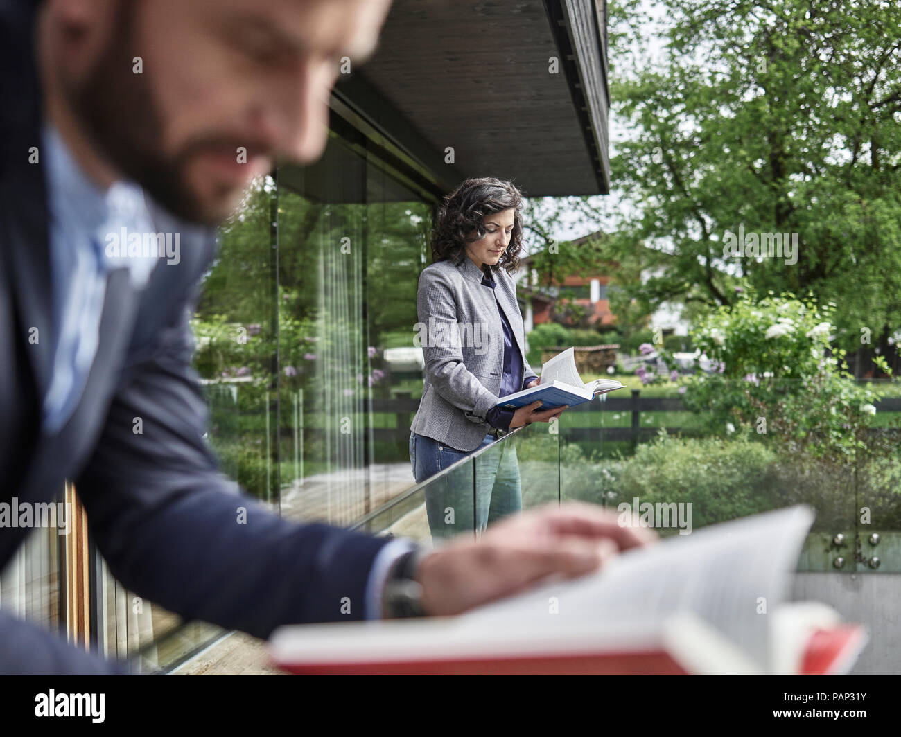 Business people reading books on balcony Stock Photo