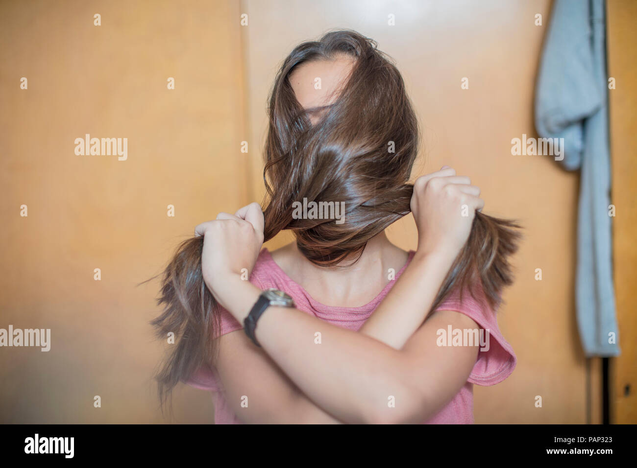 Teenage girl covering her face with her hair Stock Photo