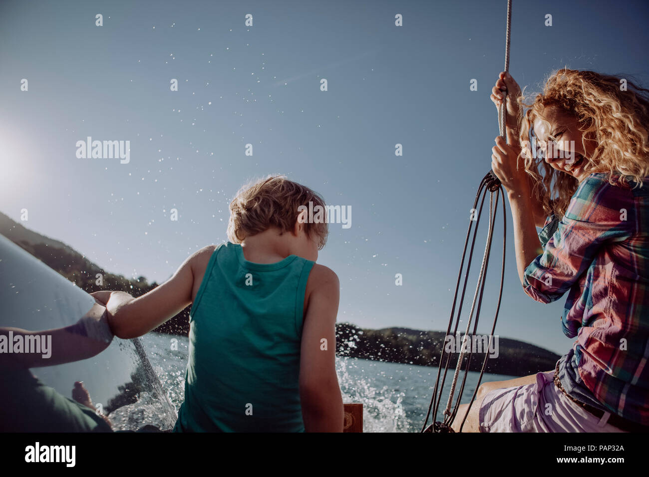 Happy mother and son sitting on a sailing boat Stock Photo