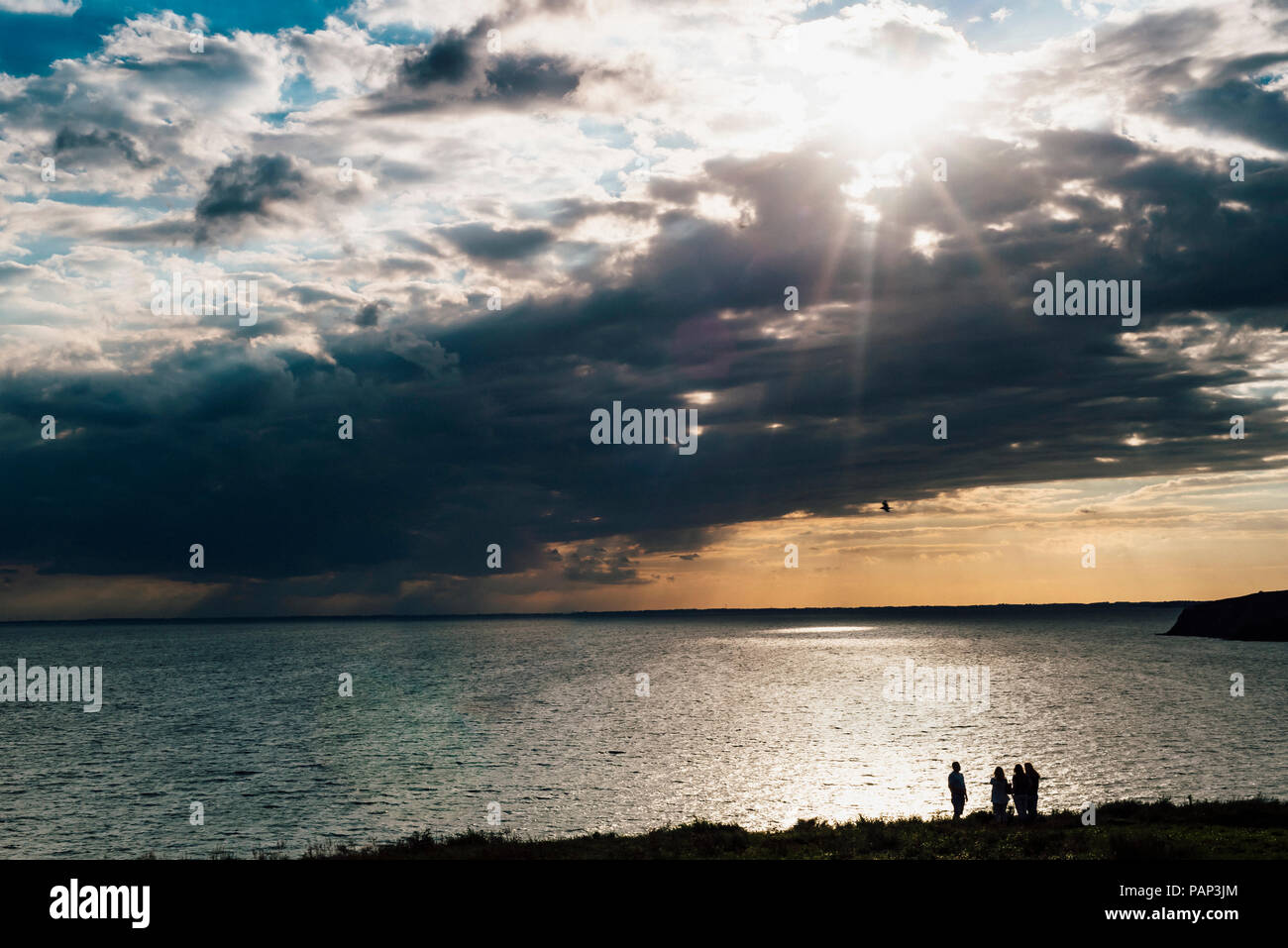 Germany, Ruegen, people at the coast and Baltic sea under cloudy sky Stock Photo