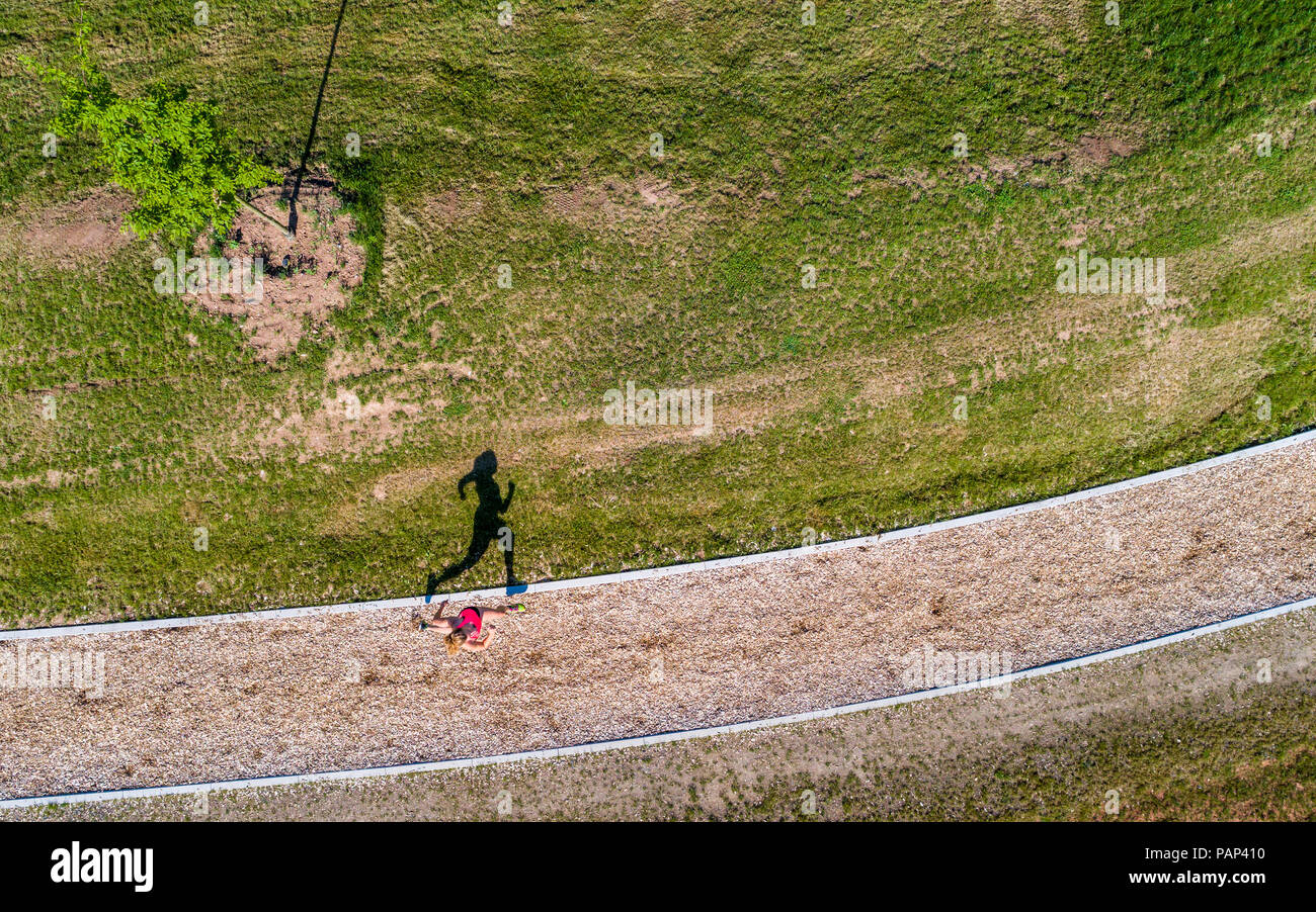 Aerial view of female jogger on woodchip trail Stock Photo