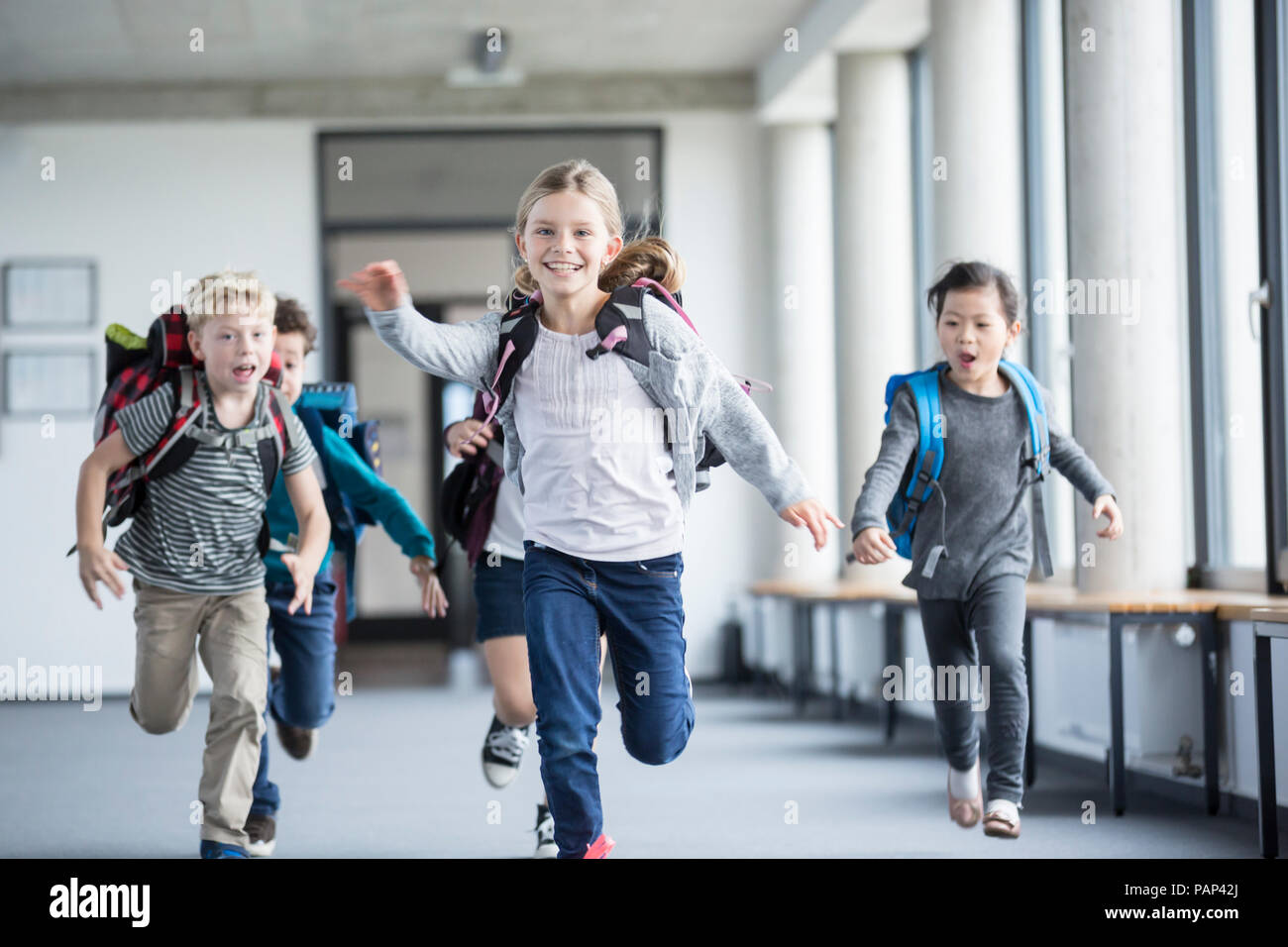 Excited pupils rushing down school corridor Stock Photo