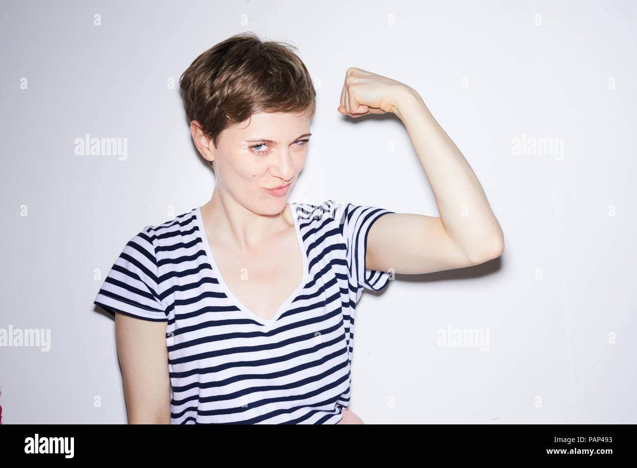 Portrait of blond woman, short hair, showing muscles Stock Photo