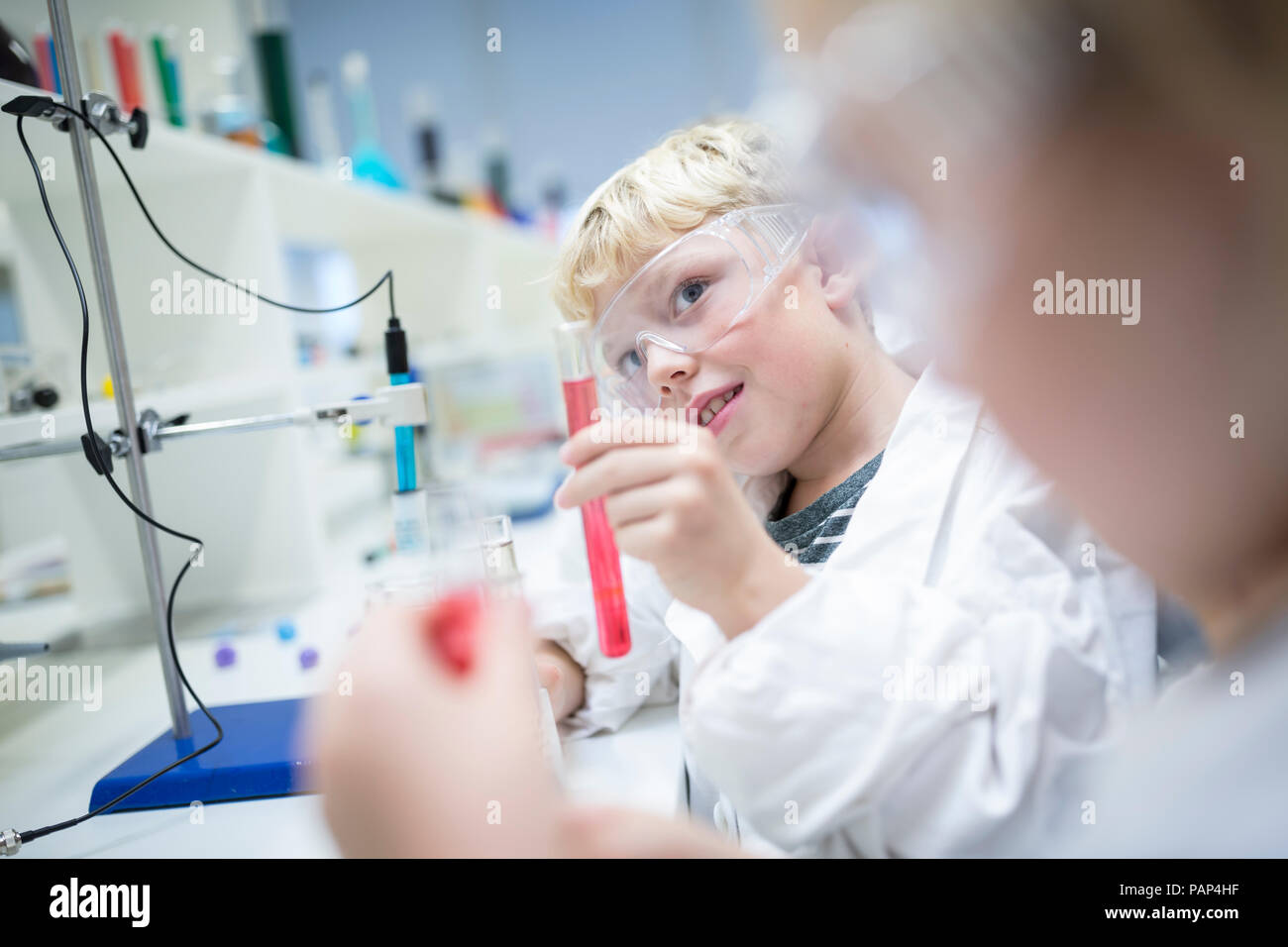 Pupils in science class experimenting with liquids in test tubes Stock Photo