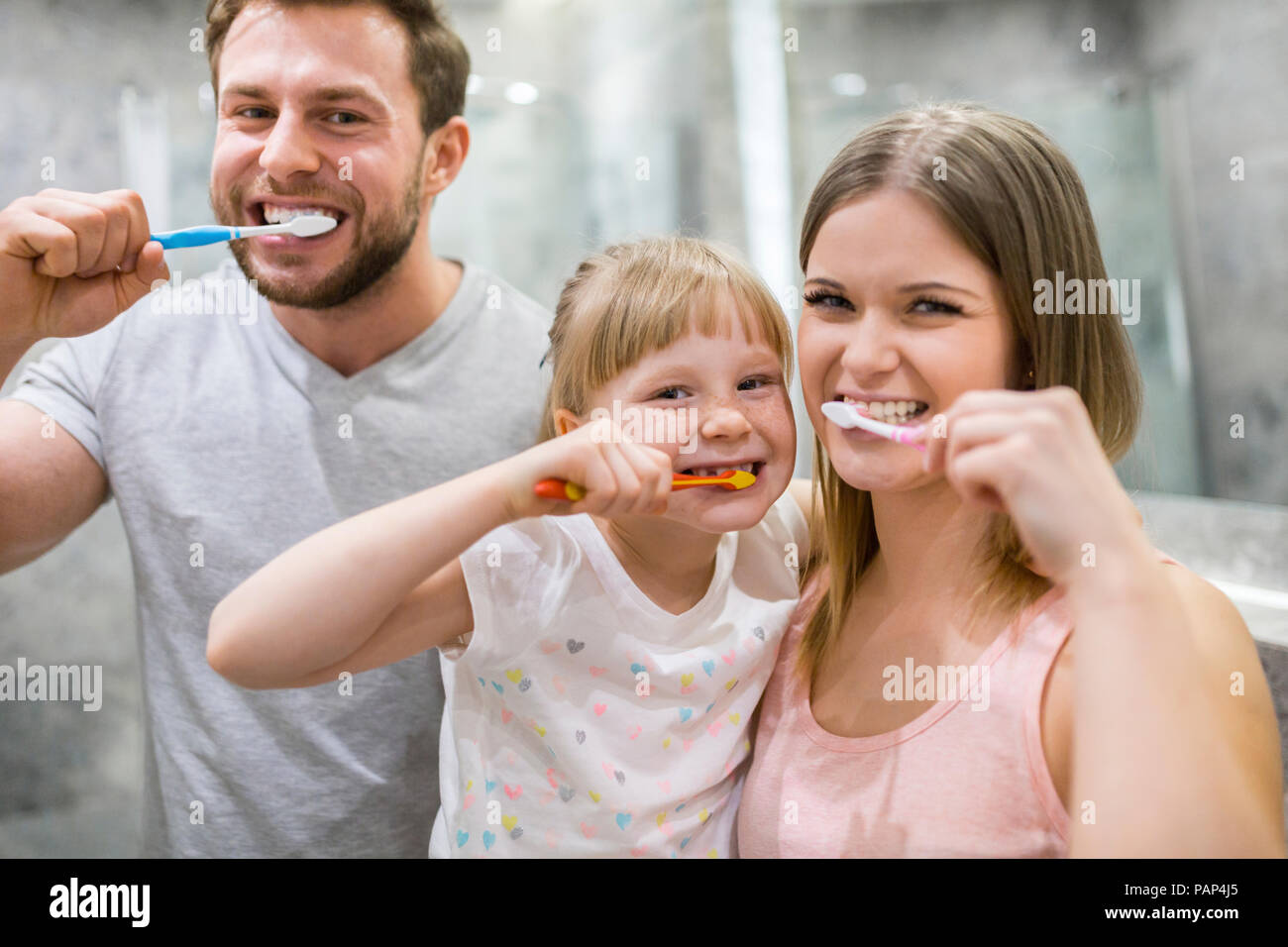 Happy family brushing teeth together Stock Photo