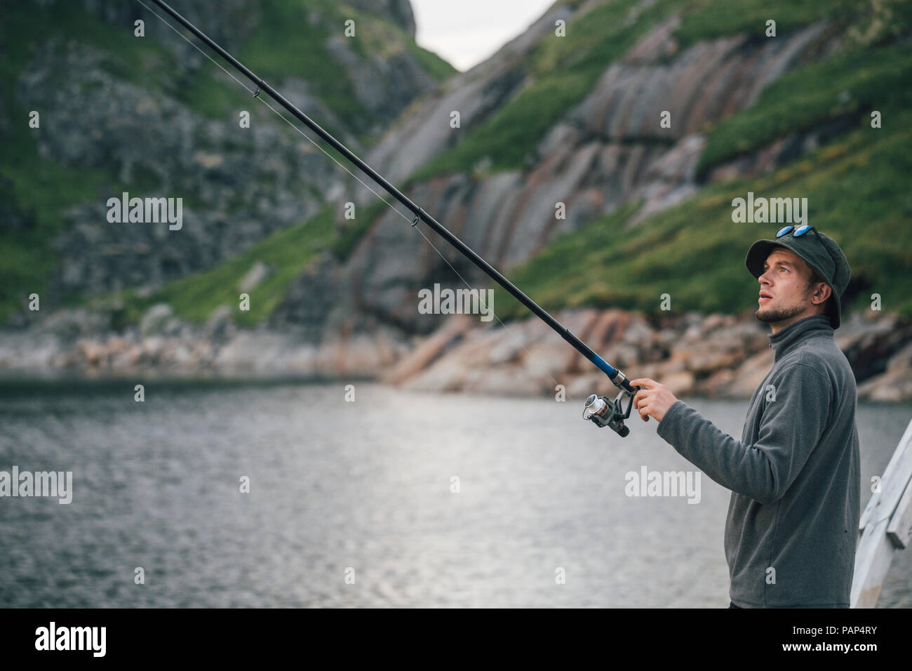 Norway, Lofoten, Moskenesoy, Young man fishing at Krokvatnet Stock Photo