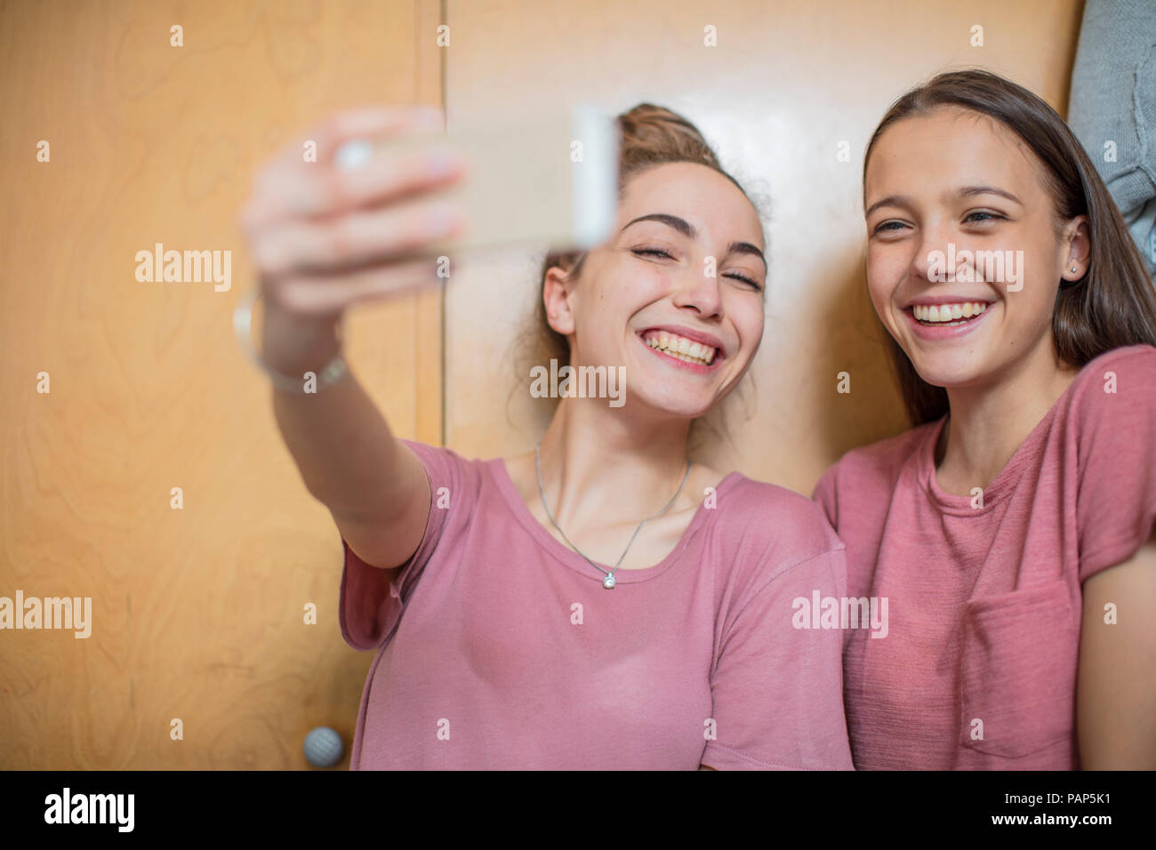 Portrait of two happy teenage girls taking a selfie Stock Photo