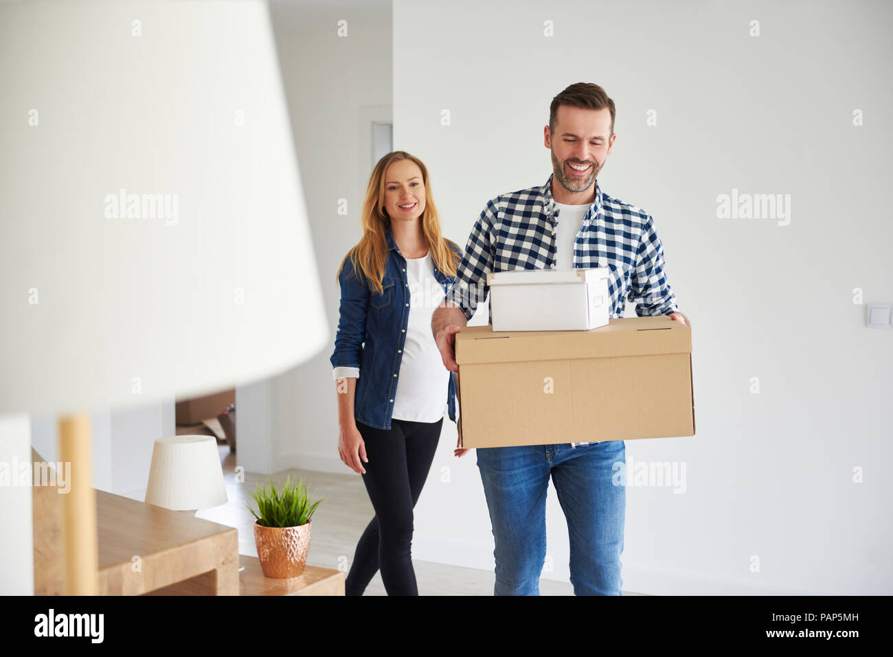 Happy couple moving into new flat carrying cardboard box Stock Photo ...