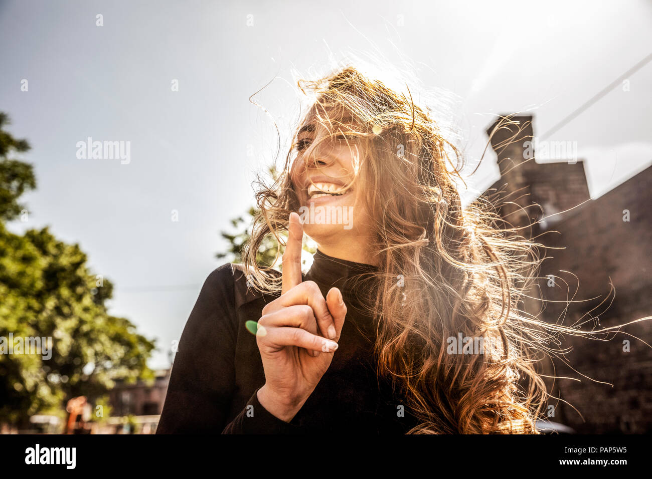 Portrait of laughing woman with blowing hair Stock Photo