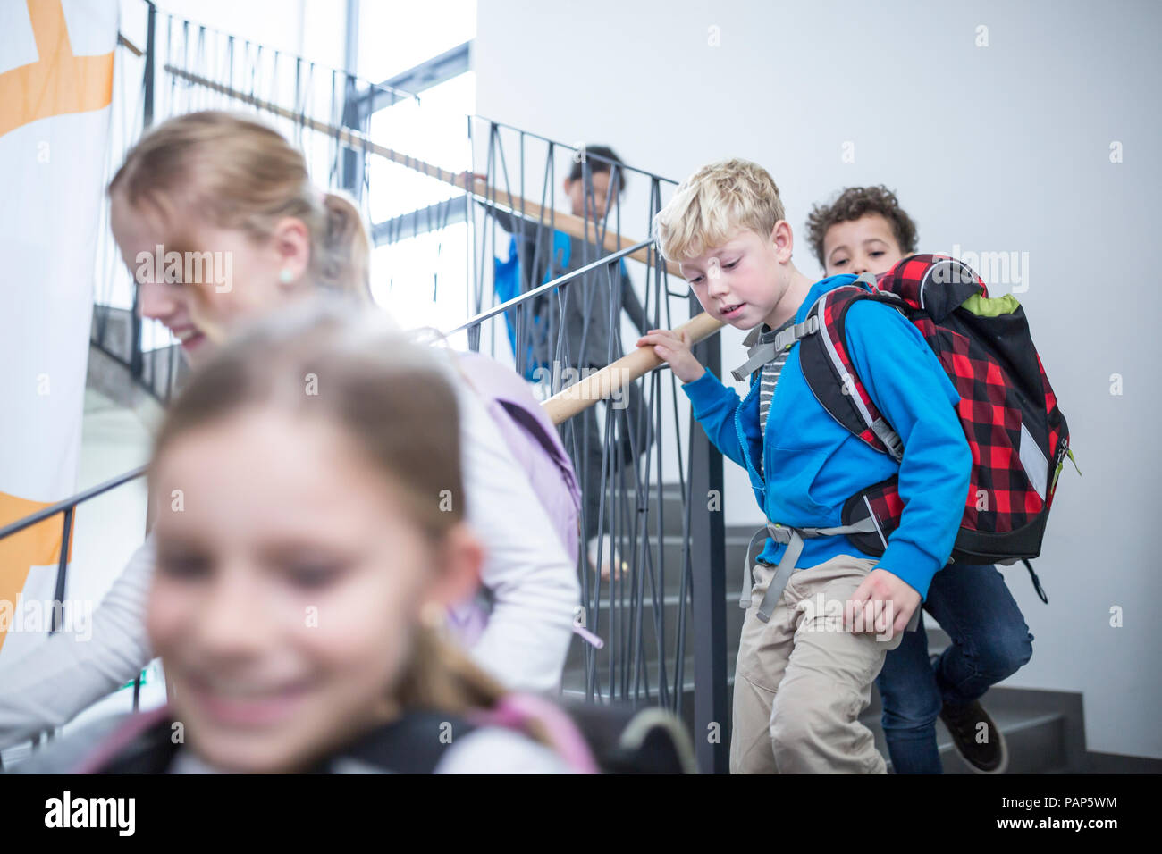 Happy pupils on staircase leaving school Stock Photo