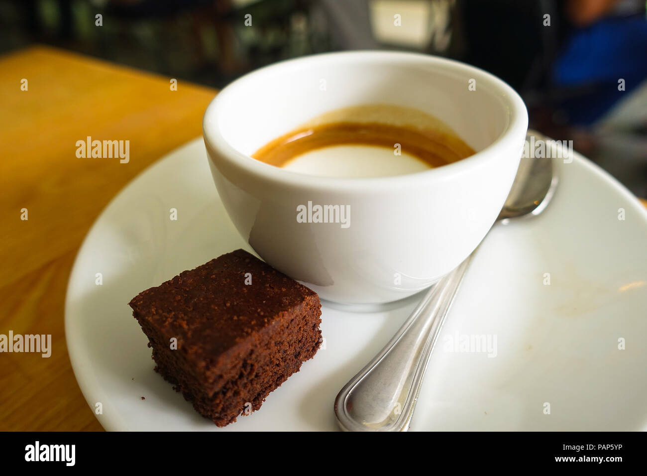 Plate, cup, and spoon accompanying an Italian latte and chocolate cake in Singapore Stock Photo