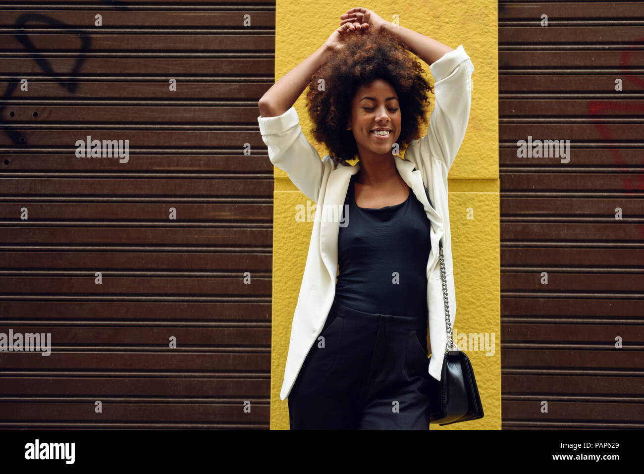 Portrait of fashionable young woman with curly hair Stock Photo - Alamy