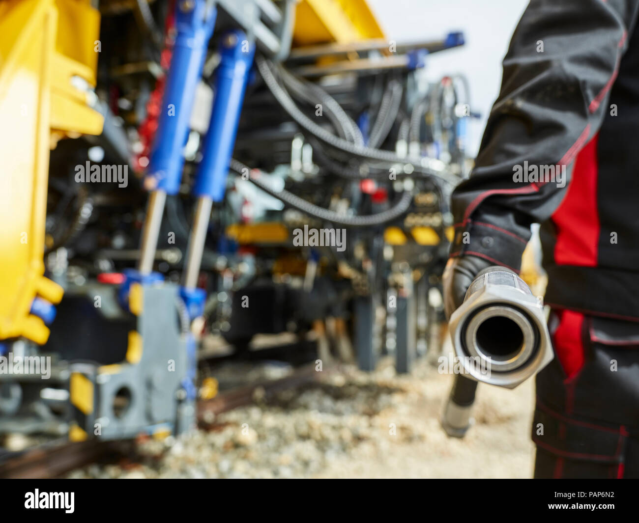 Worker with reserve hose line in front of machine Stock Photo