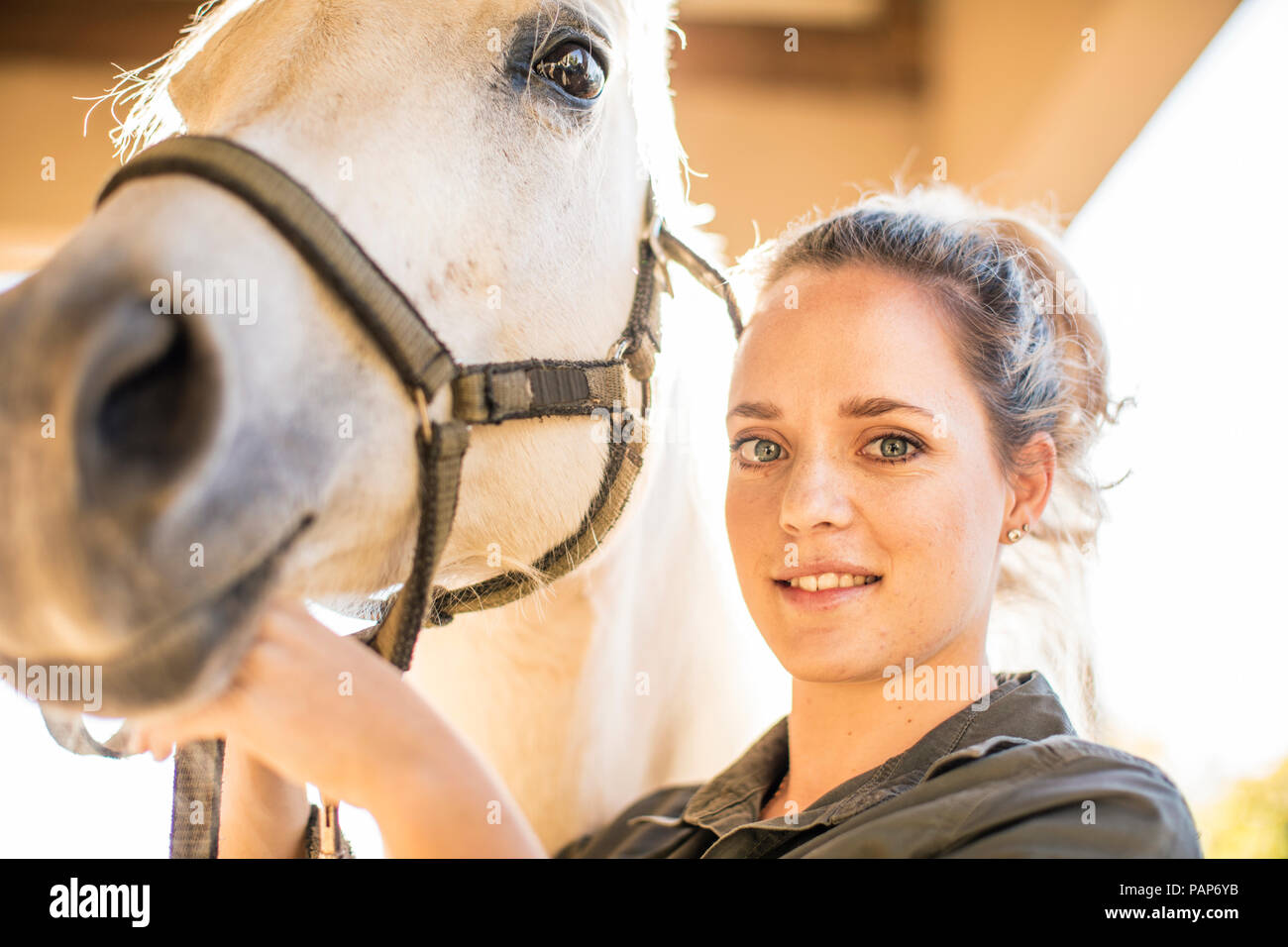 Portrait of smiling woman with a horse on a farm Stock Photo