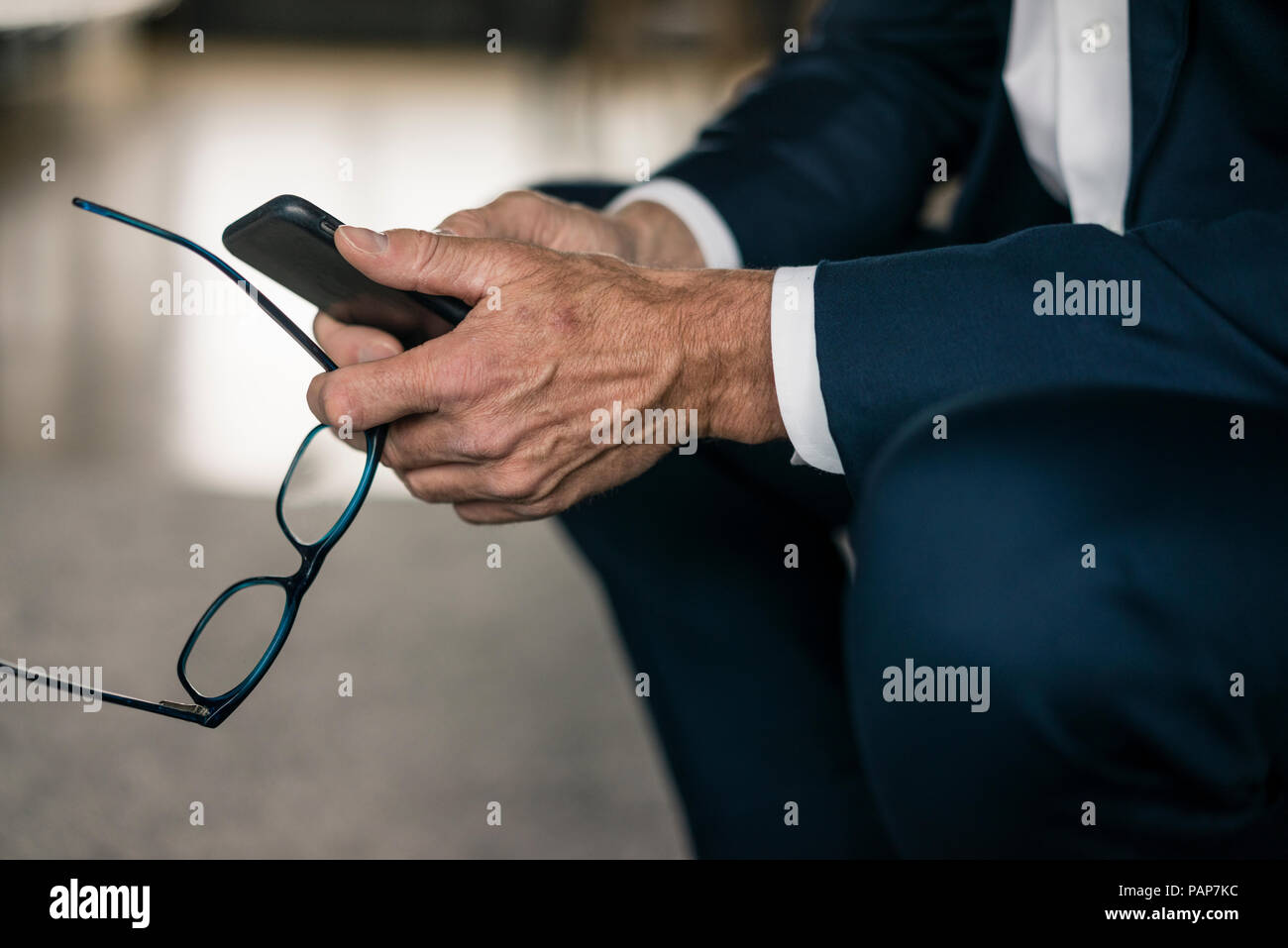 Cell phone and glasses in businessman's hand Stock Photo Alamy