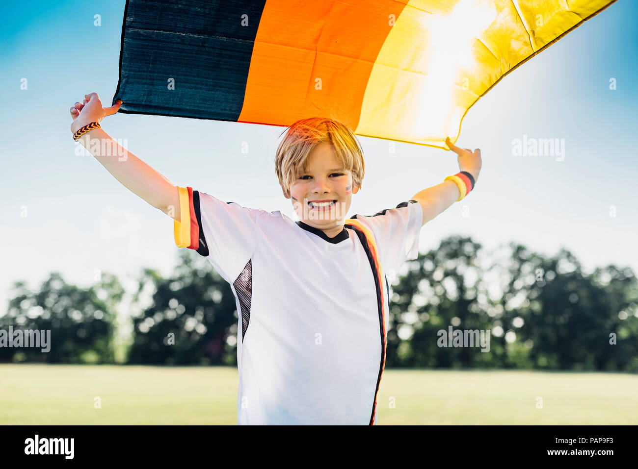 Boy, enthusiastic for soccer world championship, waving German flag Stock Photo