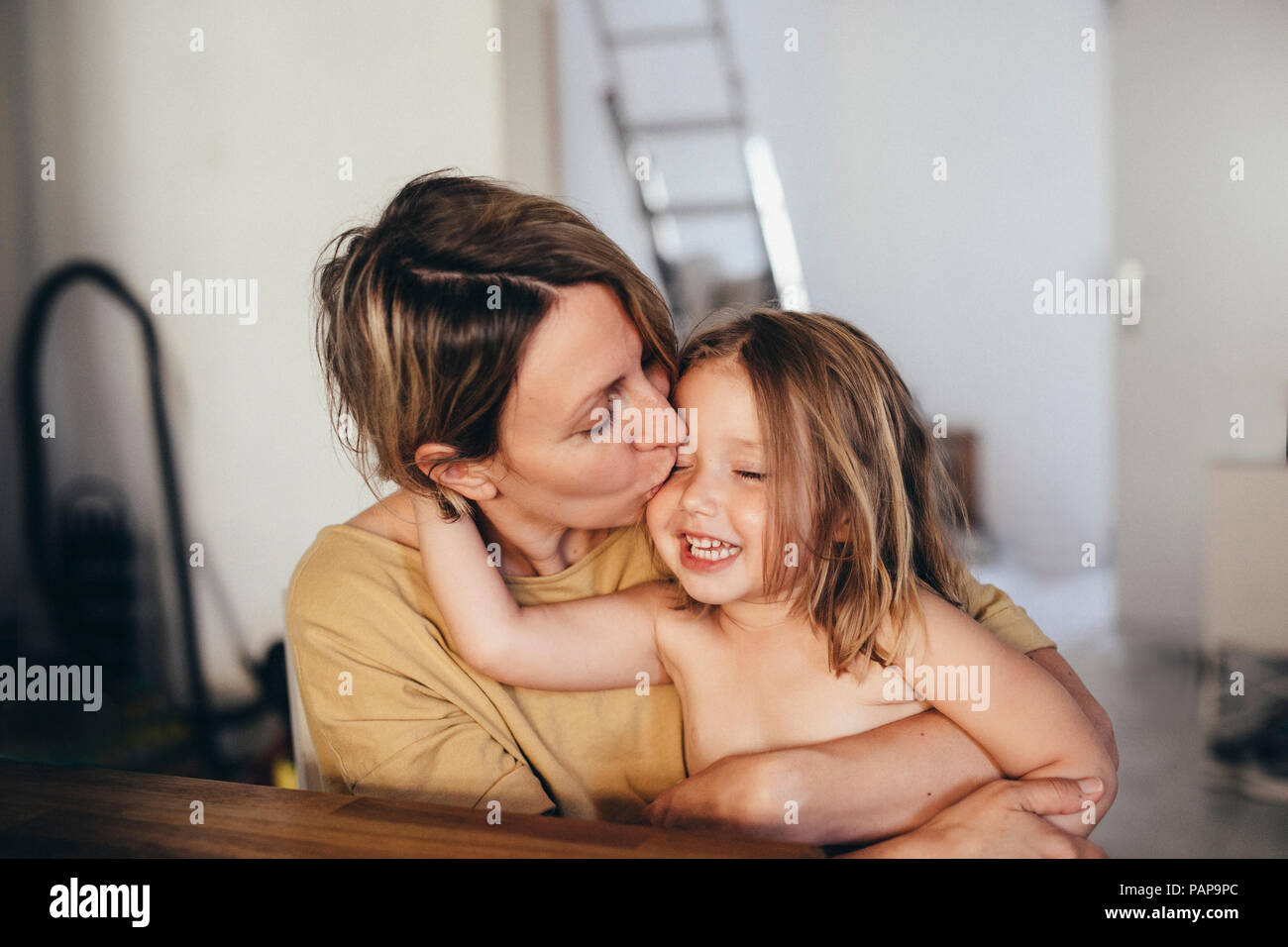 Mother kissing her little daughter  at new home Stock Photo