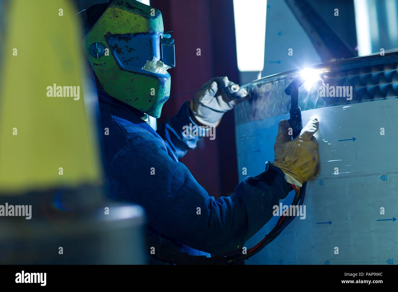 Welder in industrial plant welding tanks Stock Photo Alamy