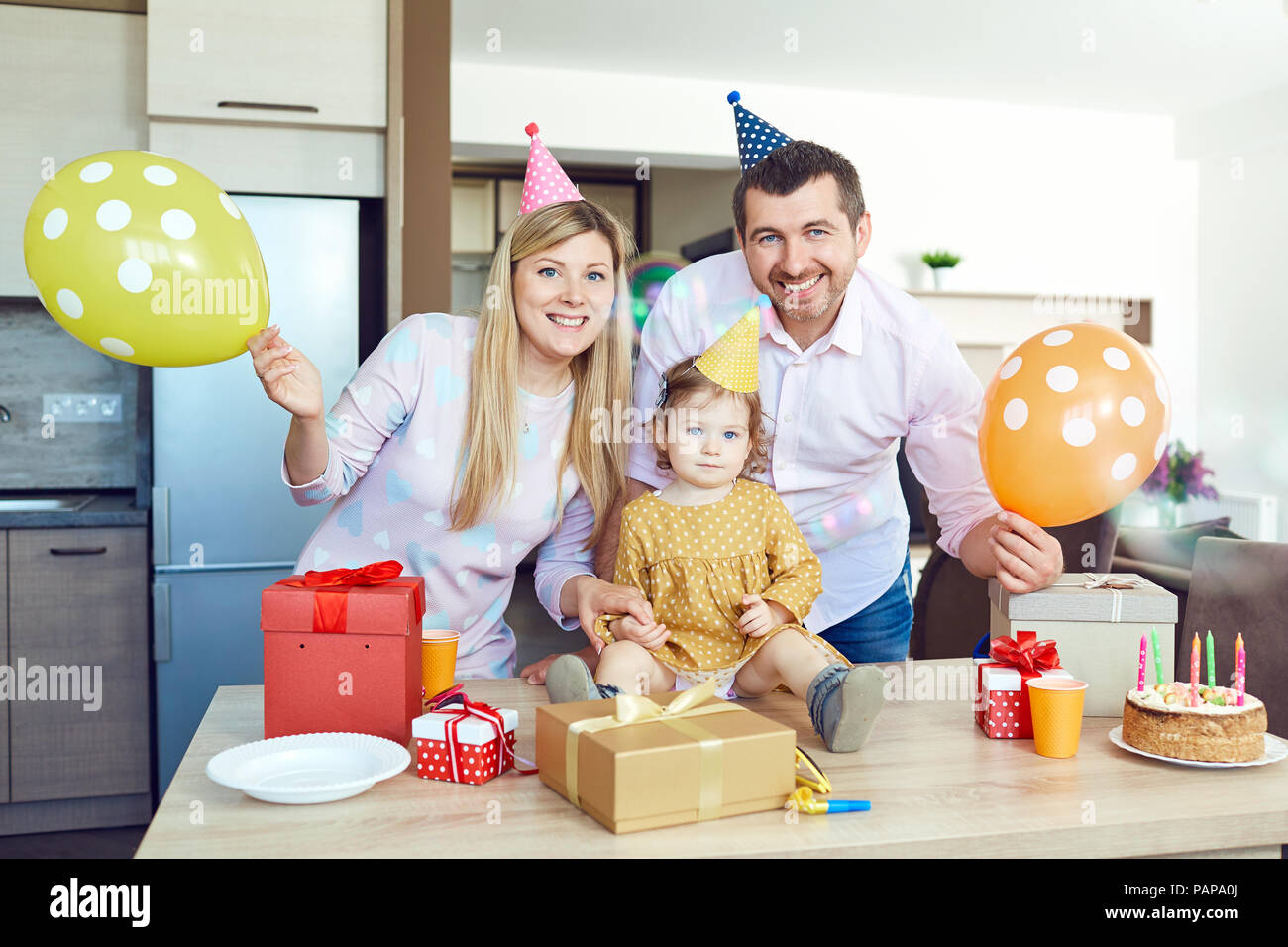 A family with a cake congratulates a happy child on his birthday Stock Photo