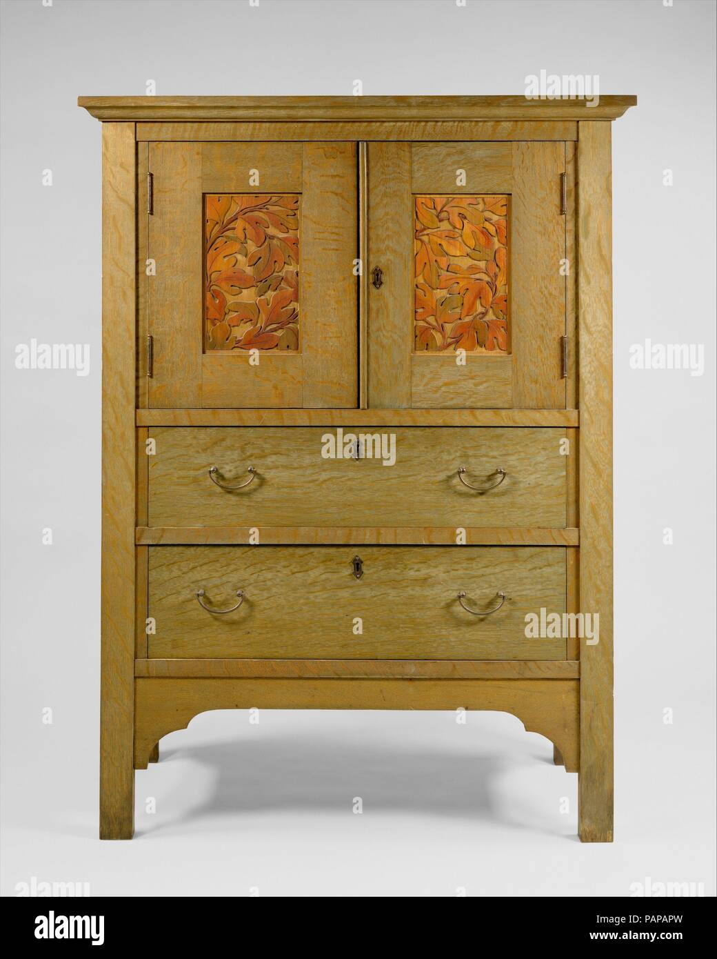 Linen Press. Culture: American. Dimensions: 55 x 41 x 18 3/4 in. (139.7 x 104.1 x 47.6 cm). Maker: Byrdcliffe Arts and Crafts Colony (American, 1902-1915). Date: ca. 1904.  The Byrdcliffe Arts and Crafts Colony was founded in 1902 outside of Woodstock, New York, by Englishman Ralph Whitehead.  Inspired by John Ruskin, Whitehead invited independent craftsmen and designers to work in traditional crafts, which included furniture, pottery, textiles, and metalwork.  This oak linen press epitomizes Byrdcliffe furniture in its simple, rectilinear shape, hand-carved panels, natural wood surfaces finis Stock Photo