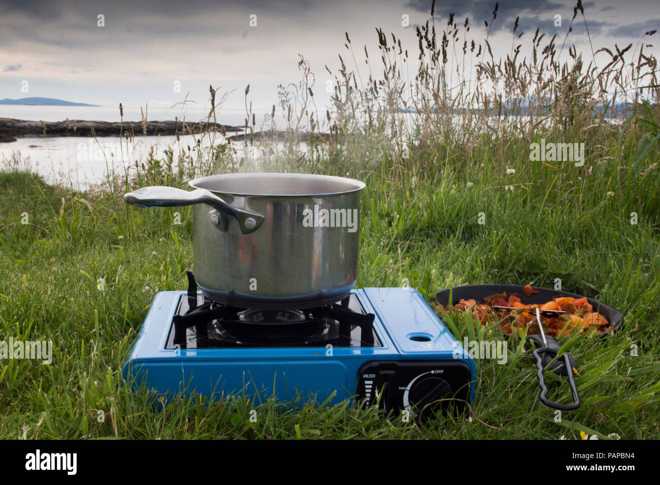 Cooking dinner on a camping cooker, wild camping during the summer, in