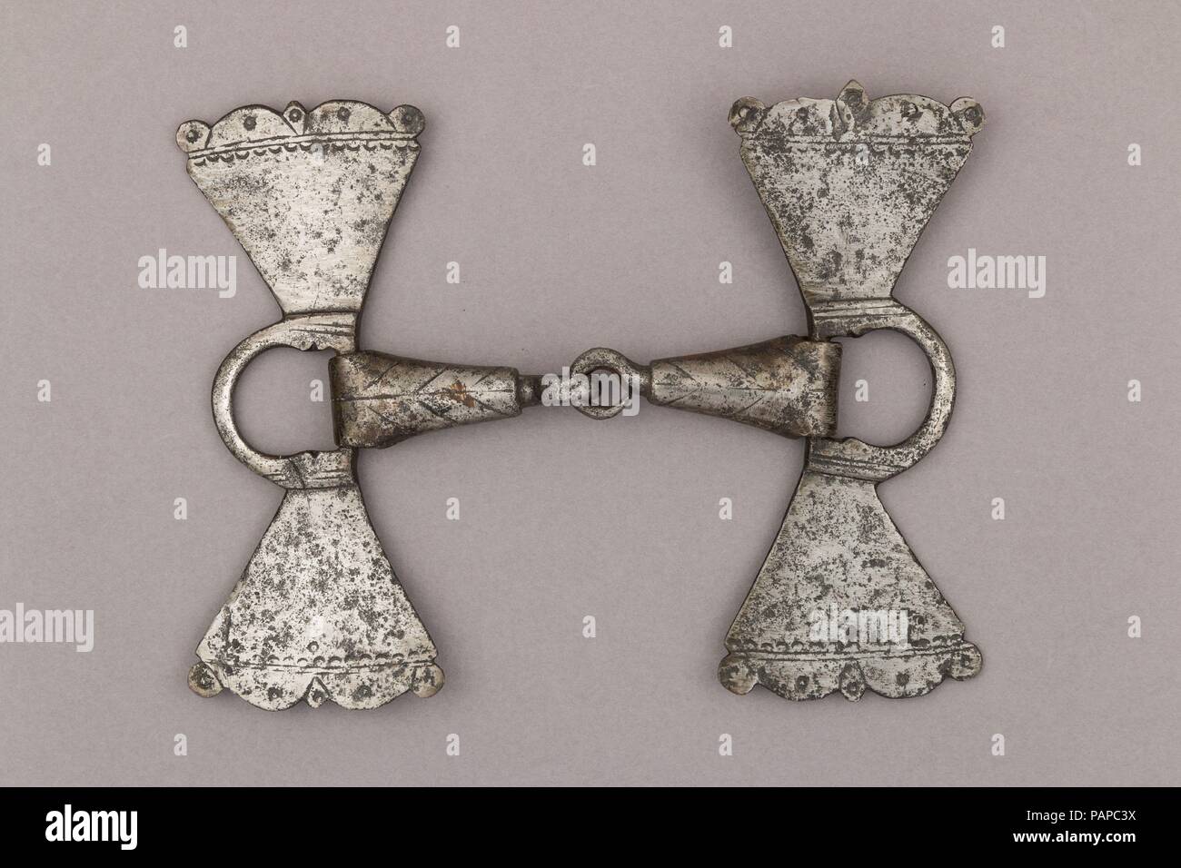 Snaffle Bit. Culture: German. Dimensions: H. 7 1/4 in. (18.42 cm); W. 9 5/16 in. (23.65 cm).. Date: late 16th century.  This kind of bit was used in the German lands for horses carrying litters and pulling sleighs.  The snaffle bit is the simplest type of horse bit, and it has an effect on the bars (part of the horses' jaw without teeth) and the corners of the lips. The scatches, the flattened triangular elements composing this mouthpiece, were slightly stronger in their effect and more resistant than the traditional conical canons also used at the time. The rings on the sides would serve to h Stock Photo