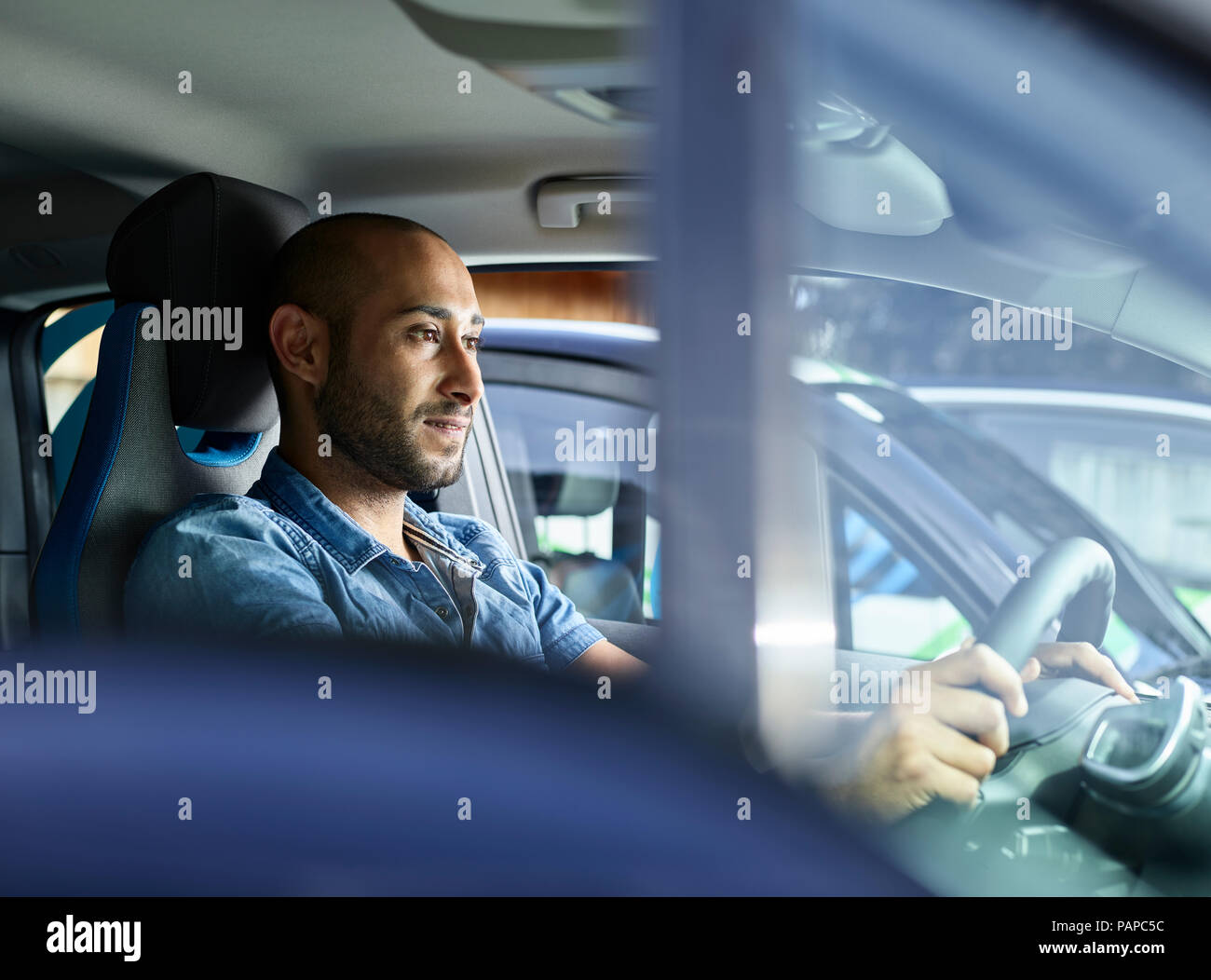 Young man driving electric car Stock Photo