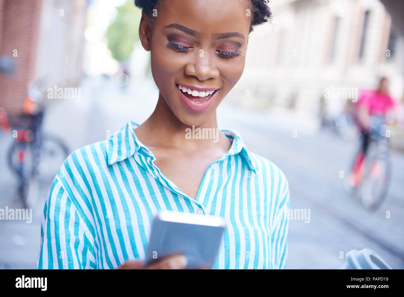 Portrait of smiling woman looking at cell phone Stock Photo