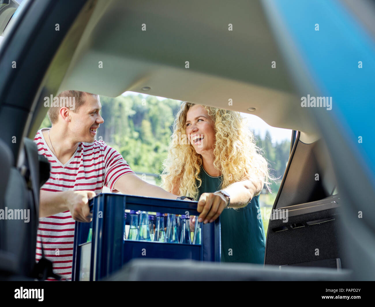 Happy couple loading boot of electric car Stock Photo