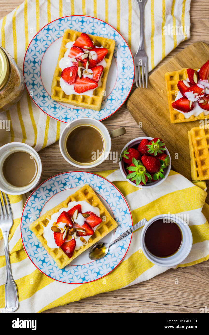 Two plates of waffles garnished with strawberries, Greek yogurt and ...