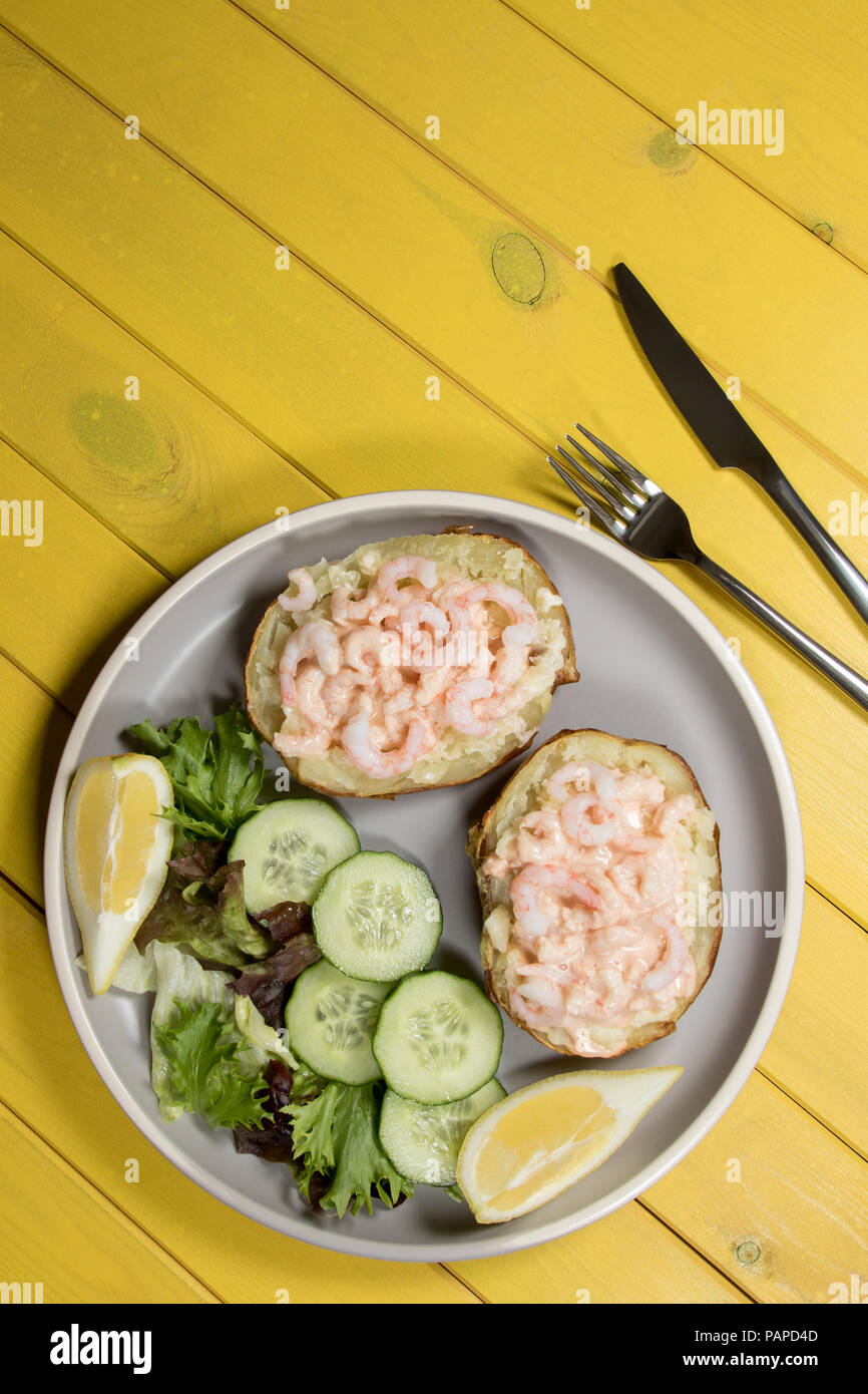 Classic healthy food. Baked potato with prawn in Marie Rose sauce and lettuce leaf side salad. Nutritional low-calorie summer slimmer meal. Stock Photo