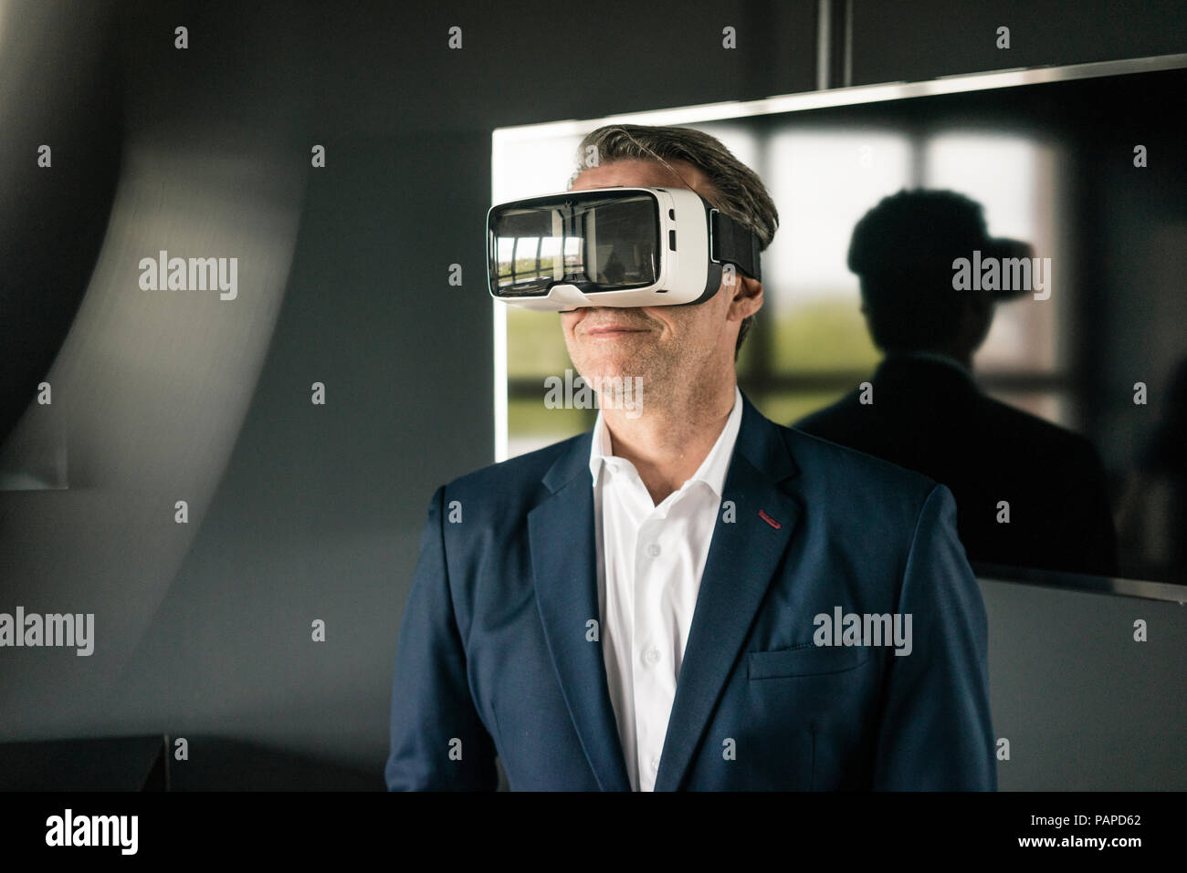 Mature businessman wearing VR glasses in office Stock Photo - Alamy