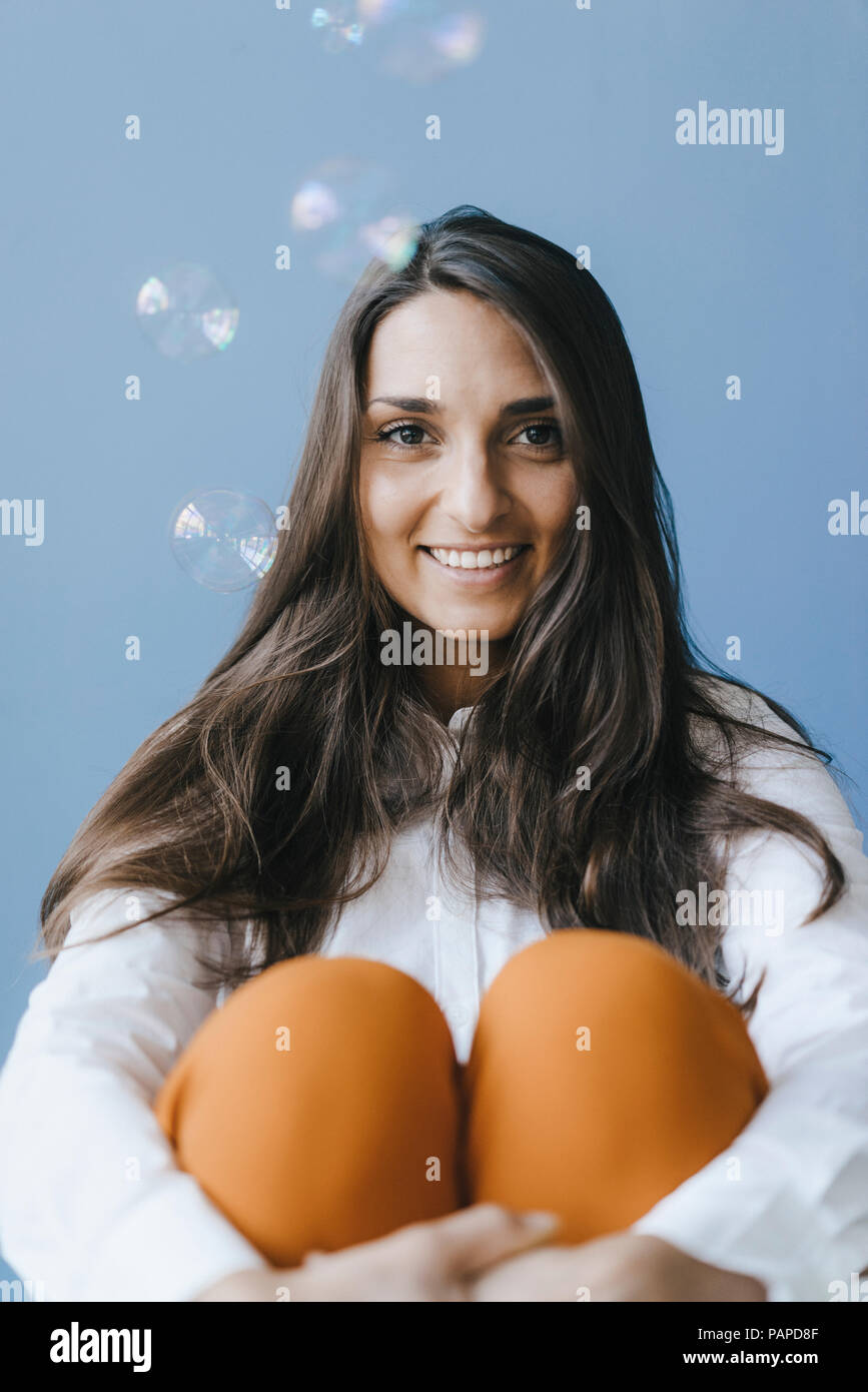 Pretty young woman playing with soap bubbles Stock Photo