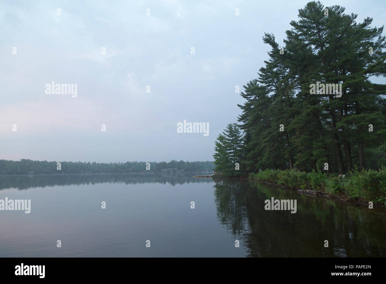Mist shrouds Gull Lake at daybreak in Ontario, Canada. Stock Photo