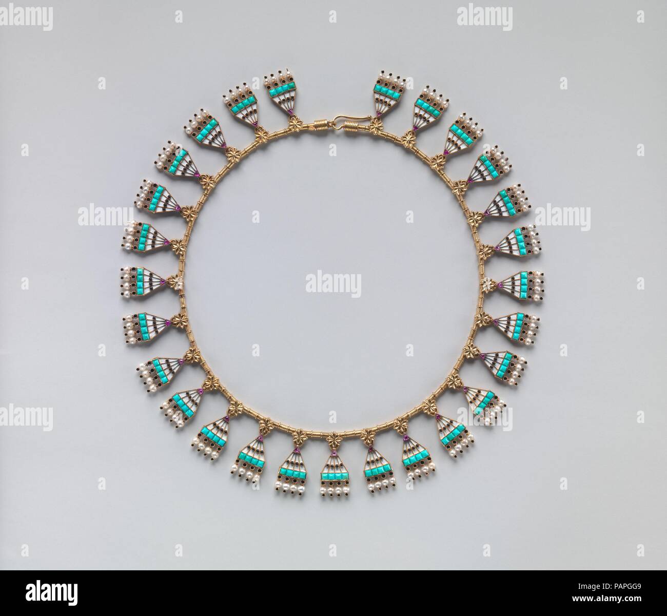Egyptian Revival demi-parure. Culture: British. Dimensions: Necklace, confirmed: 1 × 14 in. (2.5 × 35.6 cm);  Bracelet, confirmed: 7/8 × 2 3/8 × 2 1/8 in. (2.2 × 6 × 5.4 cm);  Earring, confirmed: 2 3/16 × 1 1/16 in. (5.6 × 2.7 cm). Maker: Carlo Giuliano (Italian, active England, ca. 1831-1895). Retailer: C. F. Hancock. Date: ca. 1865.  The firm of Carlo Giuliano was one of the leading producers of archaeological-revival jewelry in the second half of the nineteenth century, and this parure in the Egyptian taste reflects one of the many historical styles in which the Giuliano firm worked. It is  Stock Photo