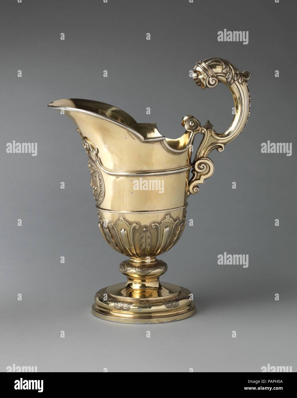 Ewer. Culture: British, London. Dimensions: Overall (confirmed): 14 1/4 x 7 3/8 x 11 1/2 in., 103 oz. 15 dwg. (36.2 x 18.7 x 29.2 cm, 3.2265kg). Maker: Samuel Margas Jr. (British, active 1714-33). Date: ca. 1721.  This massive ewer and dish was made in London for shipment to St. Petersburg.  It was part of a large order placed by Empress Catherine I, who ambitiously sought to bring fashionable western-style furnishings to her court. The ewer and dish would have been displayed on a tiered buffet for banquets and court dinners.    London's silversmiths in the eighteenth century attracted interna Stock Photo