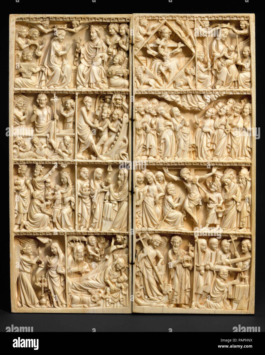 Diptych with Scenes of the Life of Christ and the Virgin, Saint Michael, John the Baptist, Thomas Becket, and the Trinity. Culture: German. Dimensions: Overall (open): 10 x 8 5/16 x 3/8 in. (25.5 x 21.1 x 0.9 cm). Date: ca. 1350.  The densely packed scenes on this large diptych depict an unusually rich array of New Testament events, apocryphal legends, and the lives of the saints. The sequence of events shown on the left panel beginning with the lower left row is: the Annunciation, Nativity, Adoration of the Magi, Presentation in the Temple, Resurrection, Descent into Hell, and Coronation of t Stock Photo