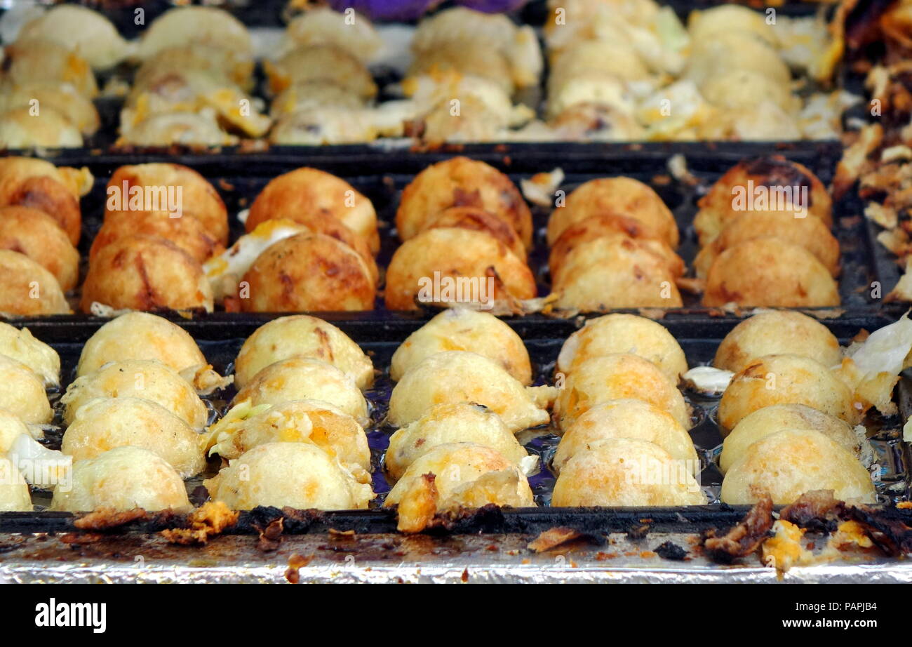 A street vendor cooks Japanese Takoyaki, or squid balls Stock Photo - Alamy