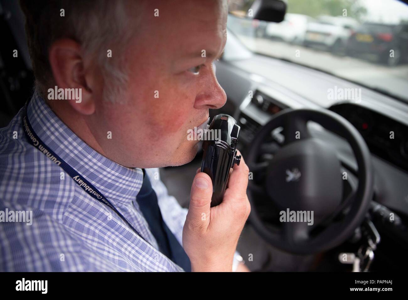 DI Andy Crowe demonstrates the in car alcohol interlock device which stops drink drivers from starting their engine if they are over the legal drink drive limit, at Durham Police headquarters. Stock Photo