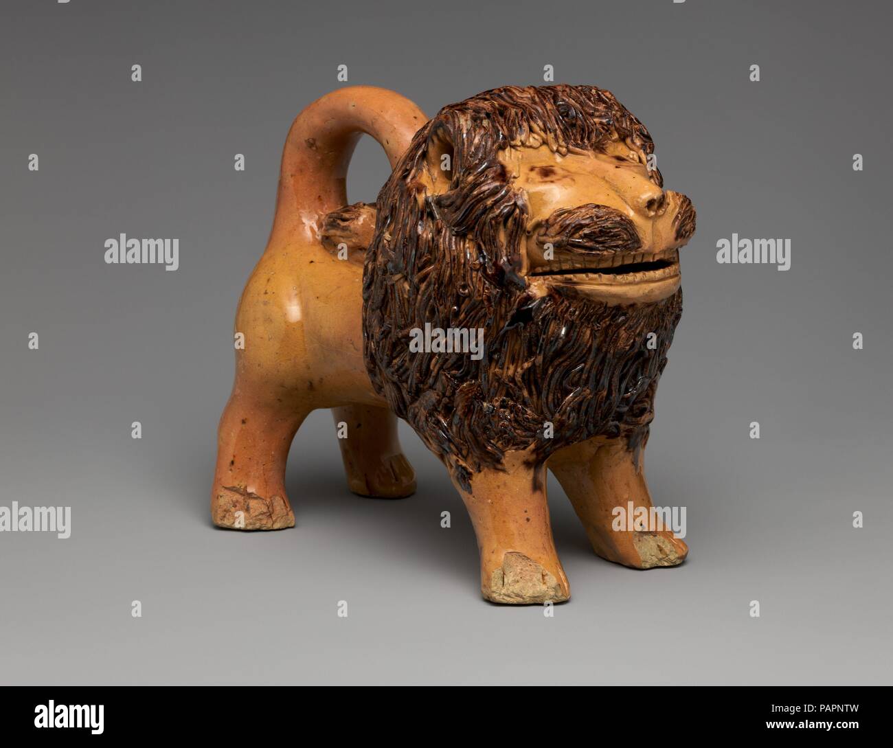 Figure of a Lion. Artist: John Bell (American, Waynesboro, Pennsylvania, 1800-1880). Culture: American. Dimensions: Height: 7 1/2 in. (19.1 cm). Date: 1845-55.  This figure of a lion is quite simply the icon of American folk art in clay. With its jaunty stance and naïve half-smile, it exhibits a high degree of charming playfulness and whimsy. Made by John Bell (1800-1880) of the Shenandoah Valley family of potters, this lion is one of only four earthenware examples known (and one of stoneware), all with history of ownership with members of the Bell family, suggesting that these special pieces  Stock Photo