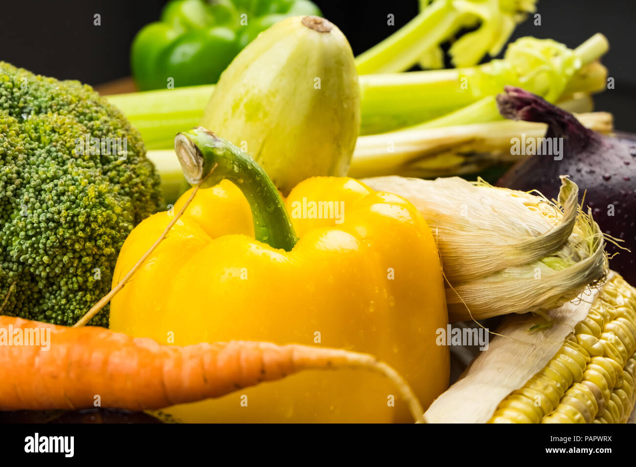 Fresh organic vegetables on rustic wood table, close-up. Locally grown bell pepper, corn and other natural vegan food laying on table Stock Photo